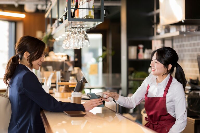 飲食店でキャッシュレス決済をする女性